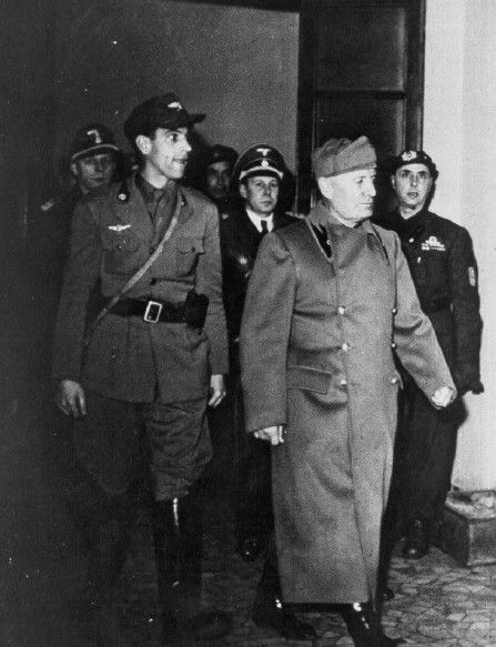 Mussolini escorted by SS body guards